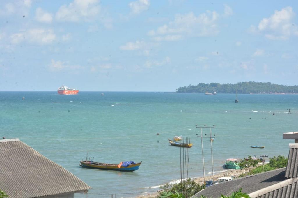 two boats sitting in the water on a beach at The Seaview Residency in Port Blair