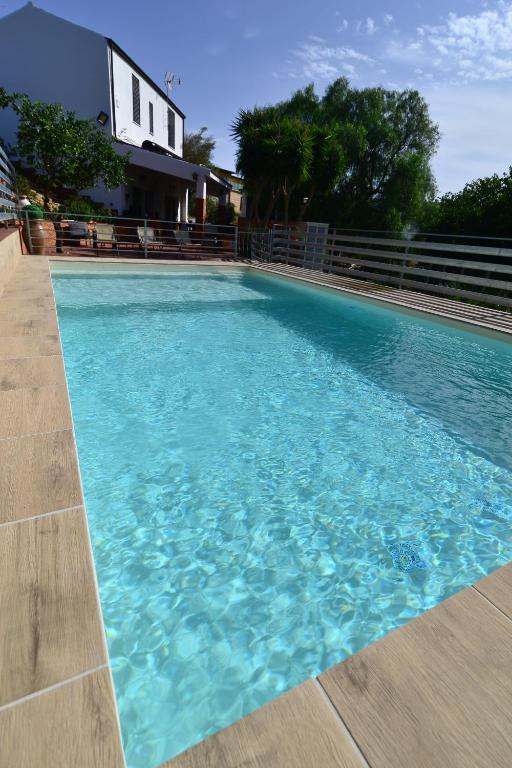 une piscine avec de l'eau bleue devant une maison dans l'établissement Villa Trappeto, à Trappeto