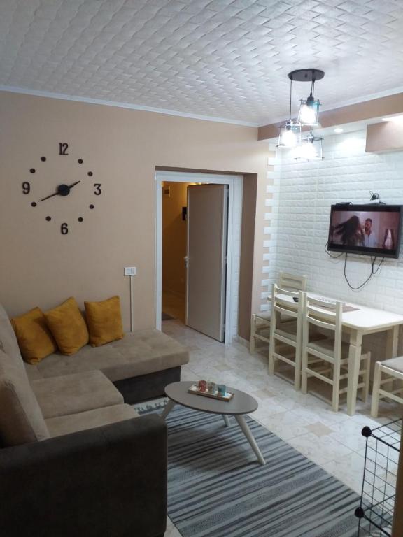 sala de estar con sofá y reloj en la pared en Friendly Apartment, en Shkodër