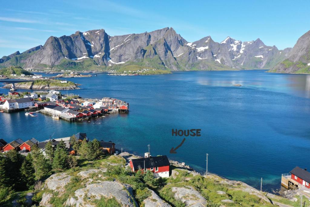 een klein stadje in een groot water met bergen bij Lofoten panoramic luxury home with sauna in Moskenes