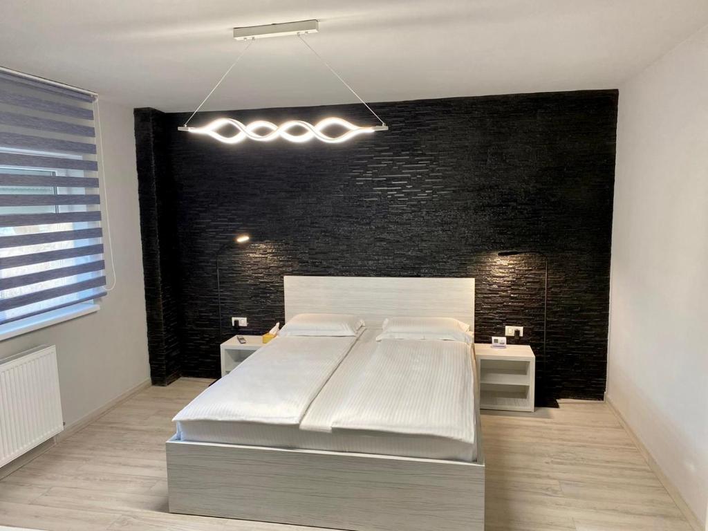 a bedroom with a large bed and a black wall at Apartament Catalin 1 in Arad