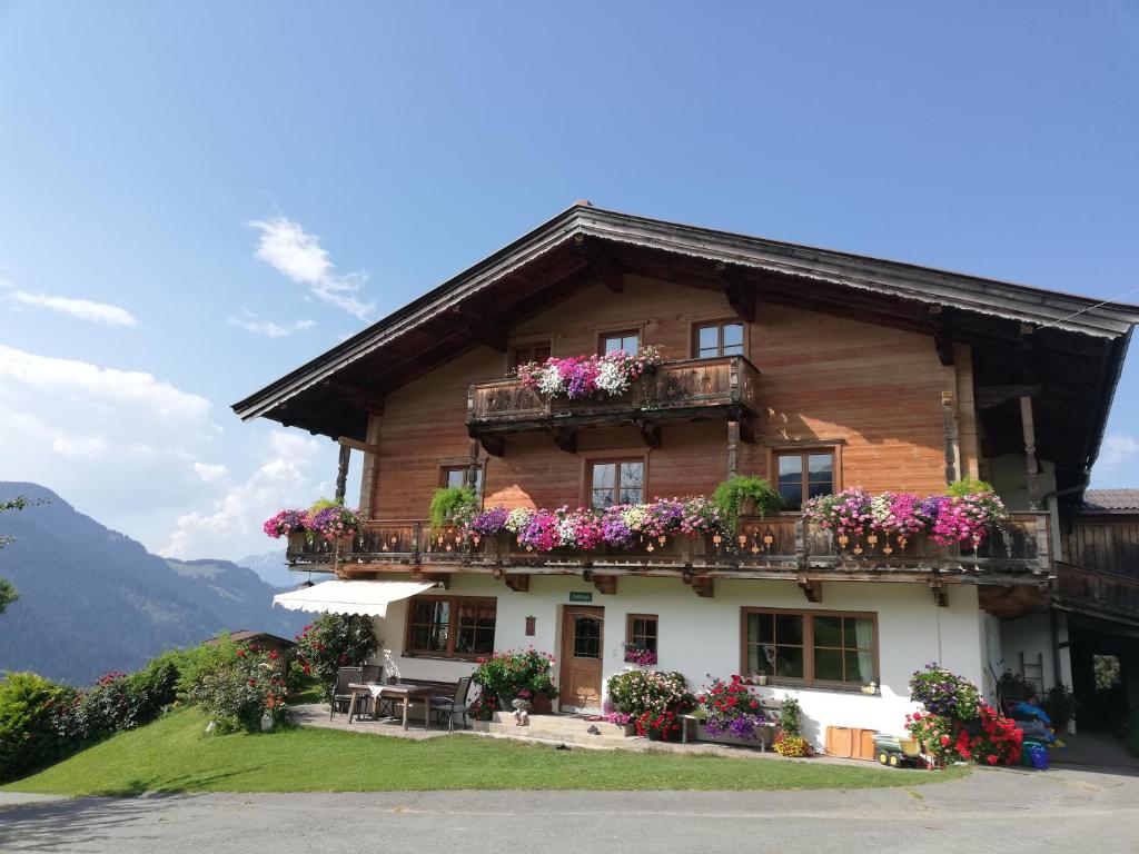 ein Holzhaus mit Blumen auf den Balkonen in der Unterkunft Ferienwohnung Hahnenkammblick in Kitzbühel