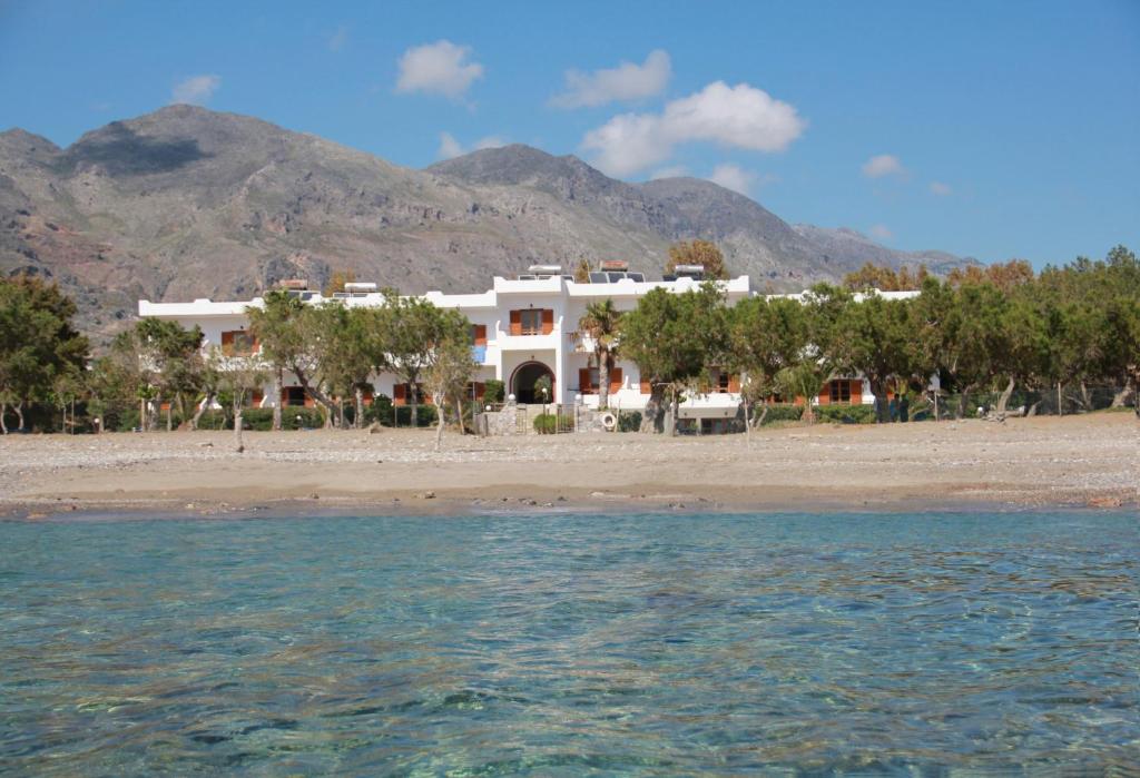 a house on the beach with mountains in the background at Studios Stavris in Frangokastello