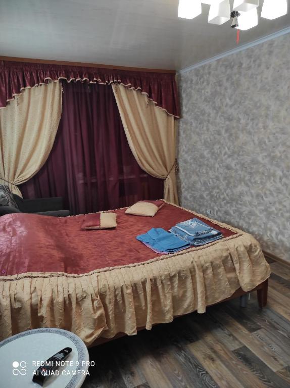 ペトロザヴォーツクにあるApartment on Krasnoflotskaya 34のベッドルーム1室(赤いシーツとカーテンのベッド1台付)