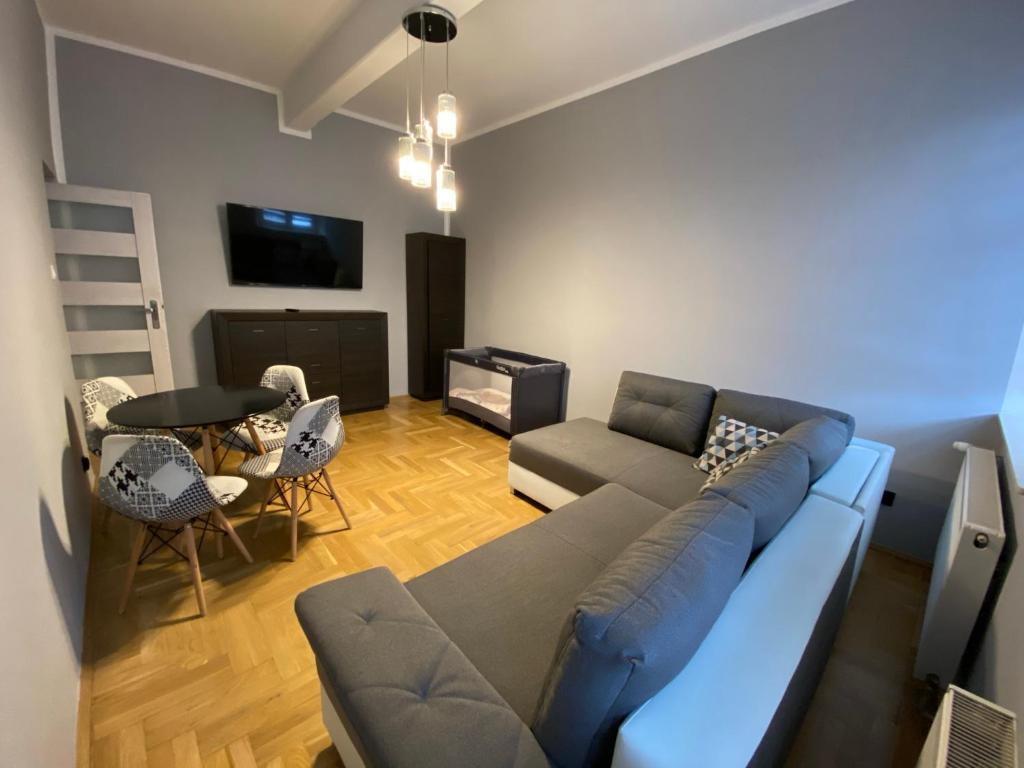 ein Wohnzimmer mit einem blauen Sofa und einem Tisch in der Unterkunft Apartament F21 Deluxe w Bielawie - Widok na Góry Sowie in Bielawa