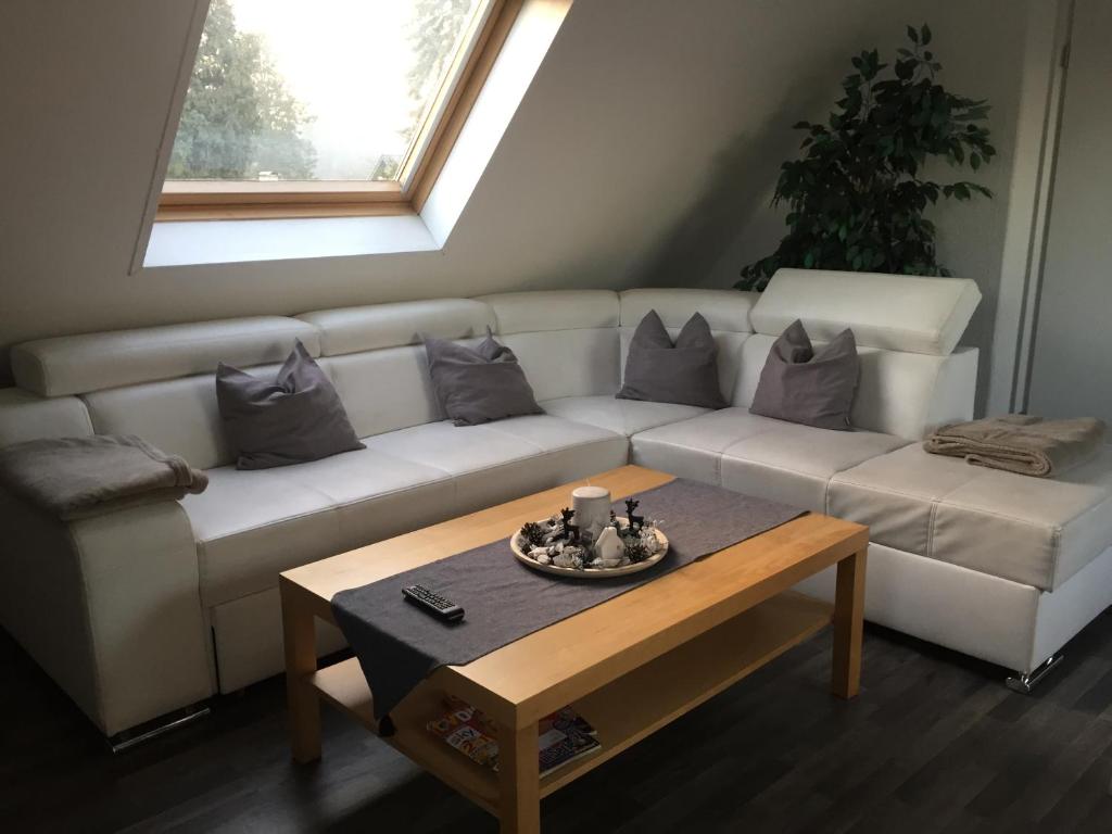 a living room with a white couch and a coffee table at Ferienwohnung Haagedoernchen in Nettetal
