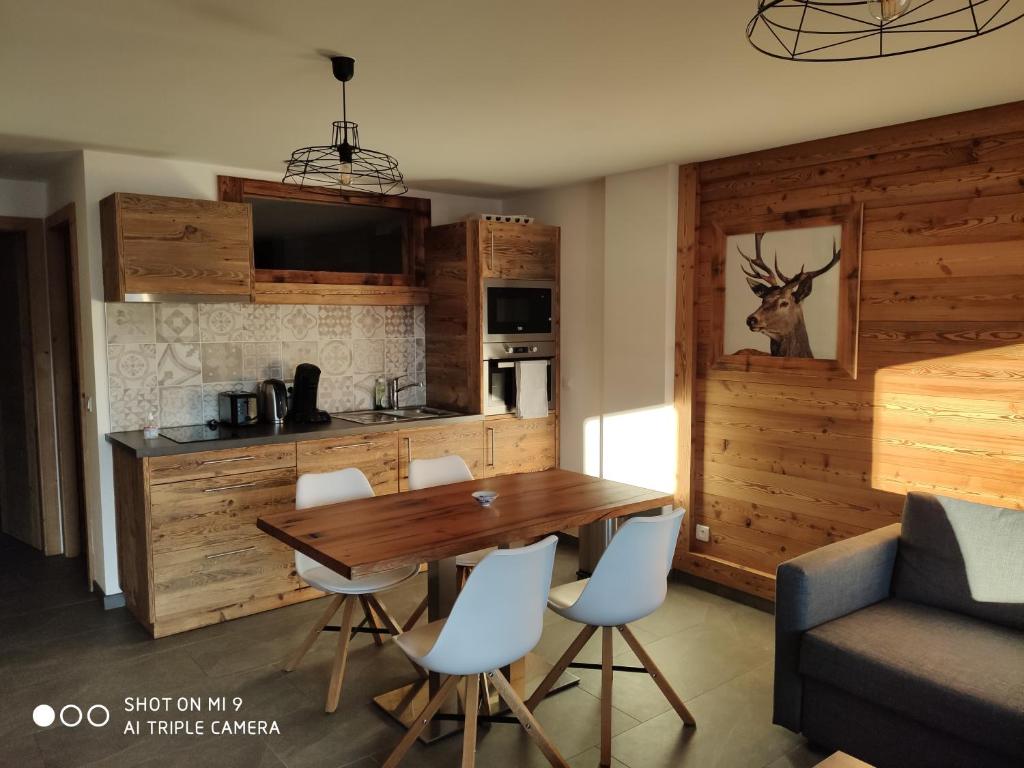 cocina y comedor con mesa de madera y sillas en LA BRESSE - Appartement de Charme, en La Bresse