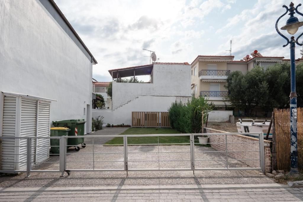 a white building with a gate in a courtyard at Mougre studios in Polychrono