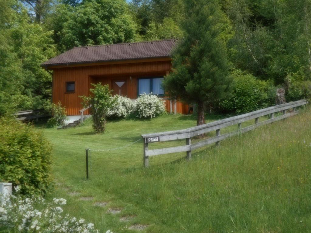 una cabaña de madera con una valla delante en Selbstversorger Hütte Rechberg en Rechberg