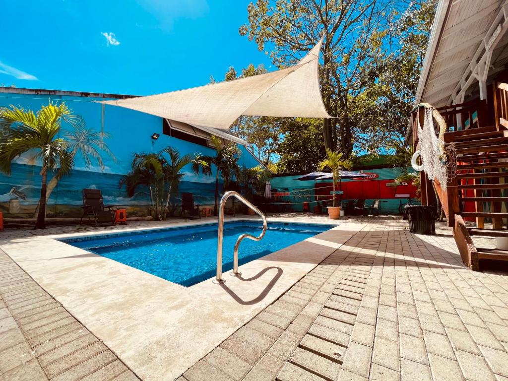 uma piscina com um guarda-sol bronzeado ao lado de uma casa em Blue Iguana em Sámara