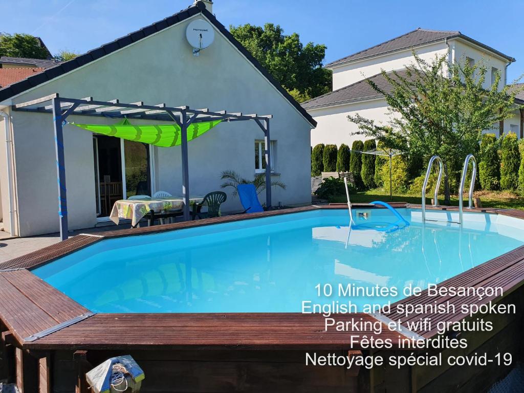 einen Pool mit einer Pergola neben einem Haus in der Unterkunft 2 vraies chambres privées au calme dans villa de campagne plain-pied 105m2 avec piscine à Montfaucon in Montfaucon