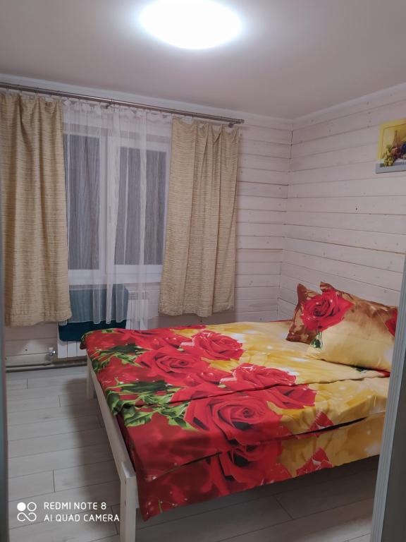 Un dormitorio con una cama con flores rojas. en Good House en Slavske