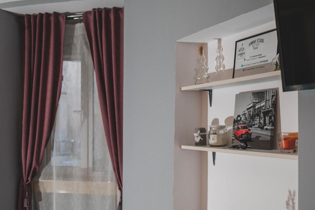 a room with a window with red curtains at Havana Studio in Braşov