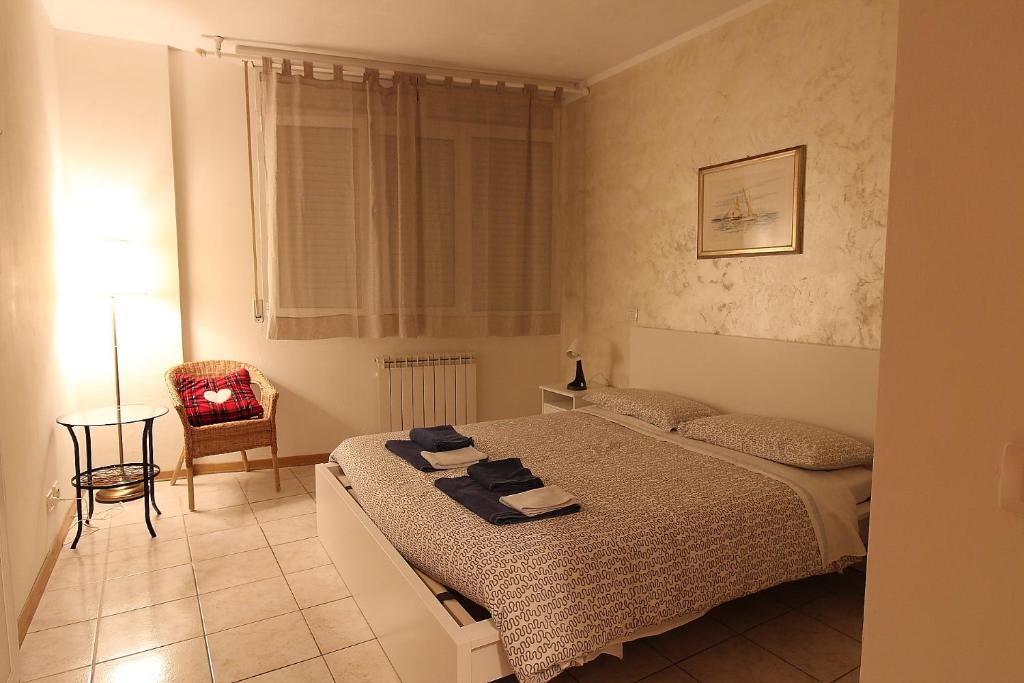 a bedroom with a bed and a chair and a table at La casa del Darda 3 in Ancona