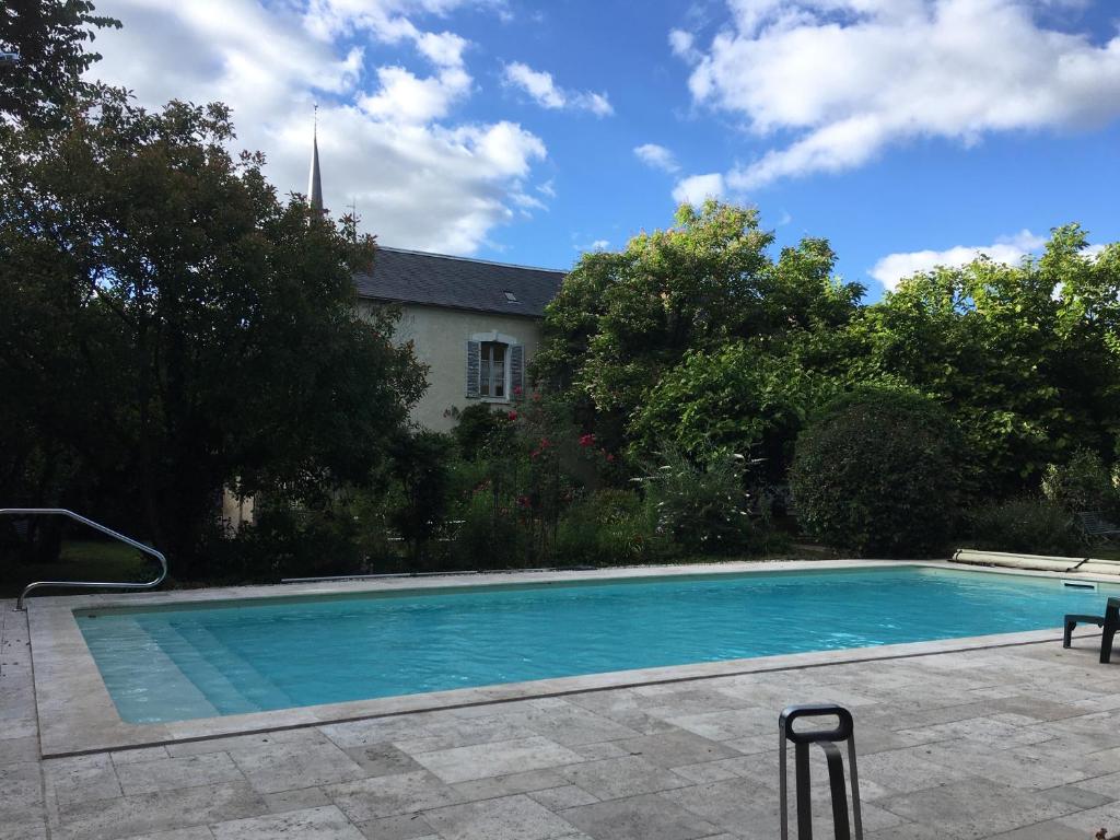 a swimming pool in front of a house at Il était une fois un jardin in Saint-Fargeau