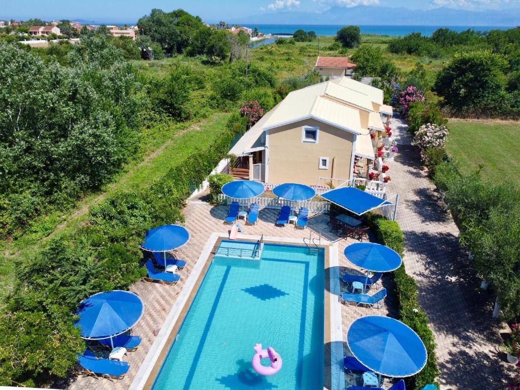 an overhead view of a swimming pool with blue umbrellas at Eleni Family Apartments in Sidari