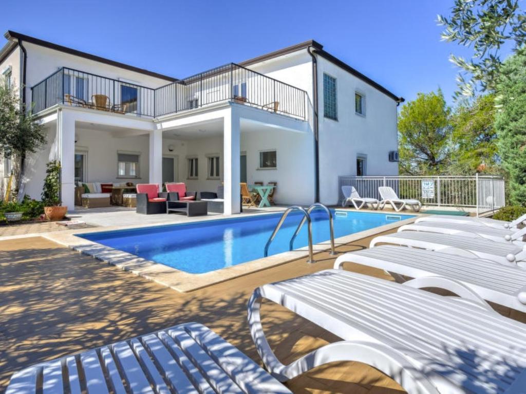 une villa avec une piscine et une maison dans l'établissement Apartments Siparis with Pool, à Zambratija