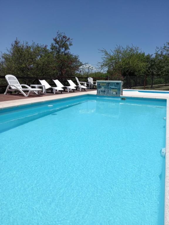 una gran piscina con sillas y un grupo en La Alquimia Casas de Campo en La Granja