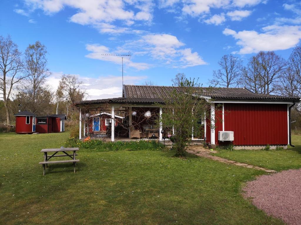 una casa con un tavolo da picnic in un cortile di Fridfullt läge mitt på Öland a Färjestaden