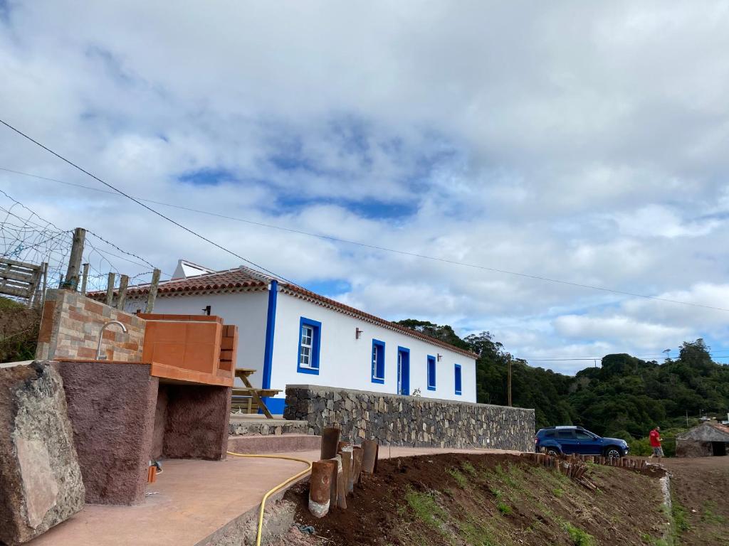 a blue and white building on a hill with a bridge at Casa da Bisa - Santa Maria - Açores in Santa Bárbara