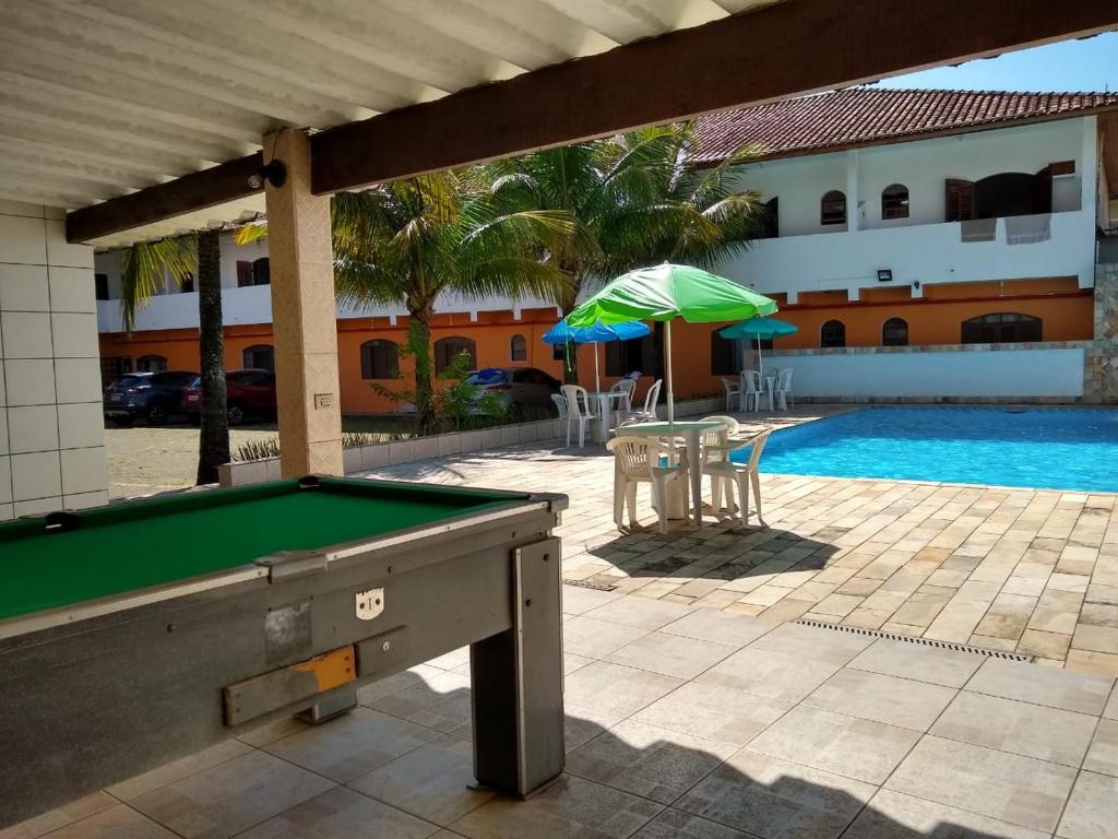 a pool table in front of a swimming pool at San Marino Hotel in Itanhaém
