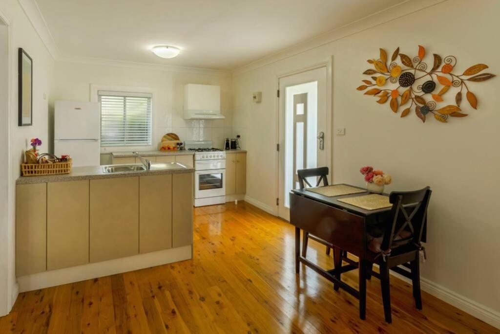 a kitchen with a desk and a table in a room at Ascot Road - discover Bowral in Bowral