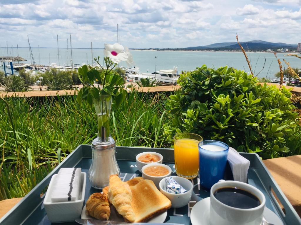 a tray of breakfast food on a table near the water at San Remo Terrazas Hotel in Piriápolis