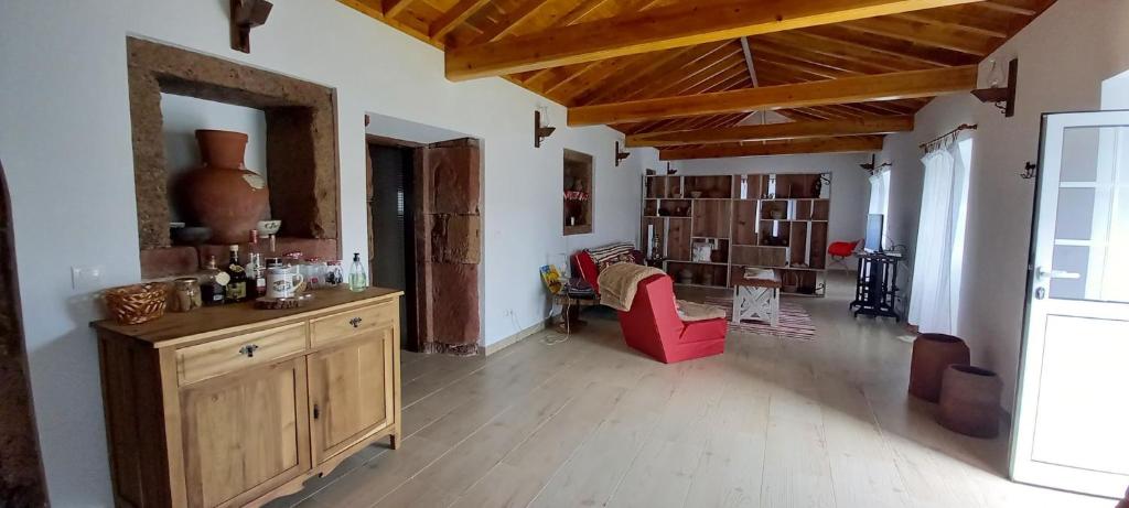 a living room with a table and a red chair at Casa da Bisa - Santa Maria - Açores in Santa Bárbara