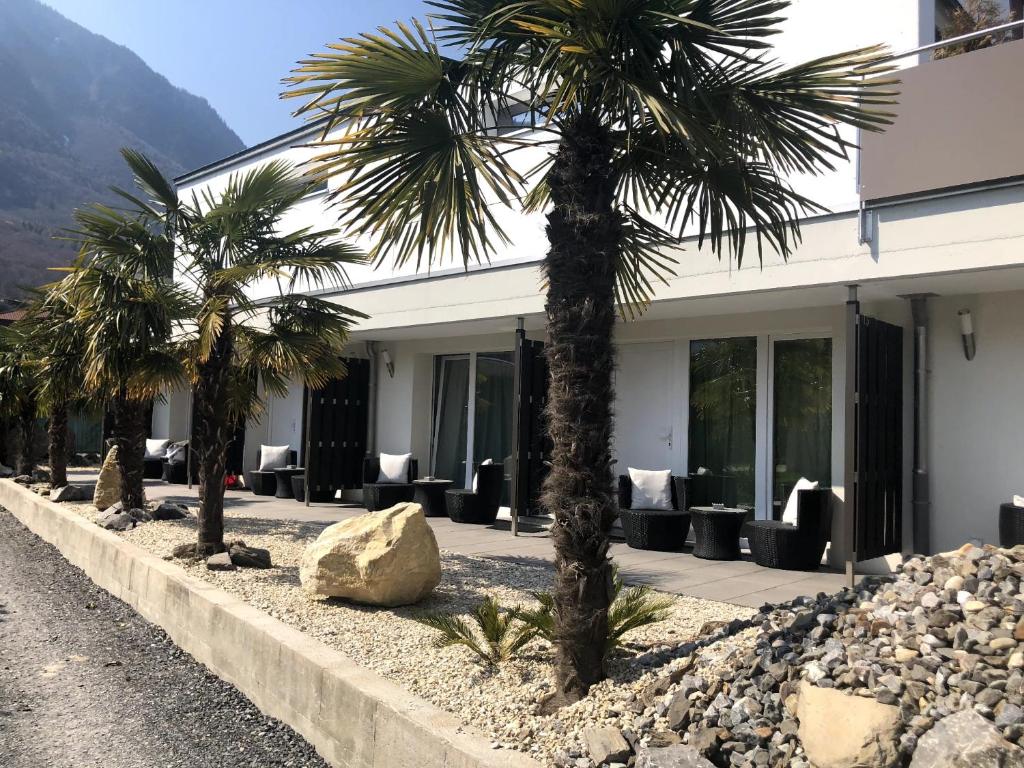 two palm trees in front of a building at Amelia in Port-Valais