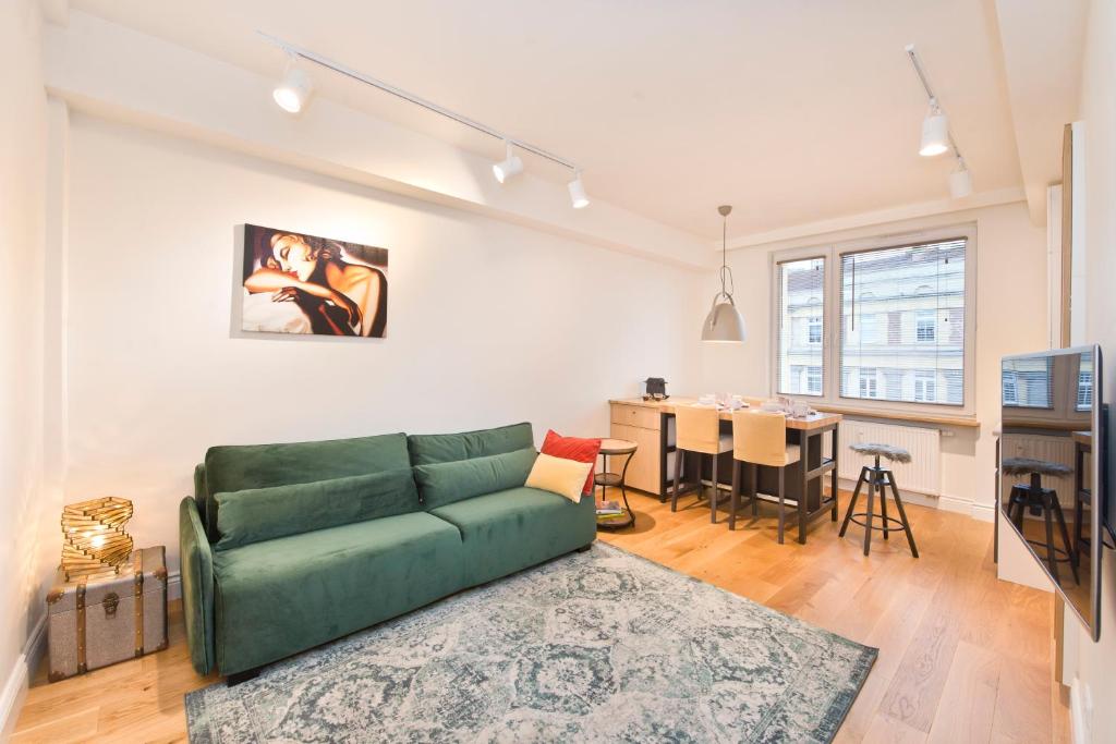 a living room with a green couch and a table at Apartament Świętojańska in Gdynia