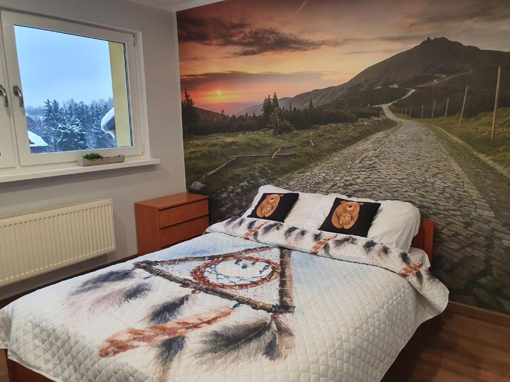 ein Schlafzimmer mit einem Bett mit einem Gemälde einer Straße in der Unterkunft Kinapp Stay in Szklarska Poręba