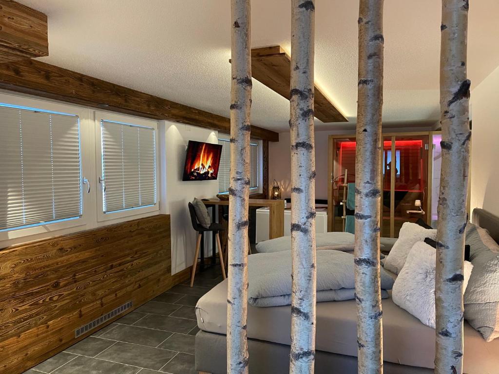Cette chambre comprend 4 lits avec des arbres. dans l'établissement Mountainsuite, à Oberwald