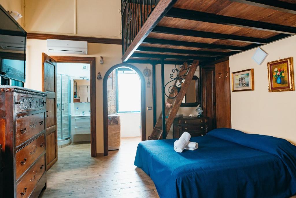 una camera da letto con un letto blu e un orsacchiotto sopra di Casa Vincenzina ad Atrani