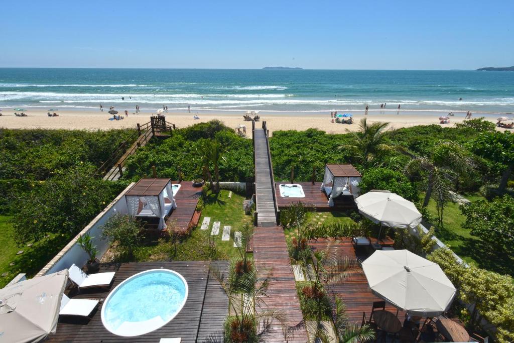 uma vista para a praia a partir da varanda de um resort em Hospedaria Home Suites Mariscal em Bombinhas