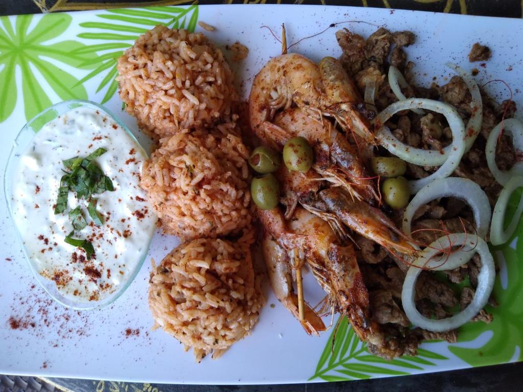 um prato de comida com camarão e arroz numa mesa em The Lighthouse at Casa Max em Bocas Town