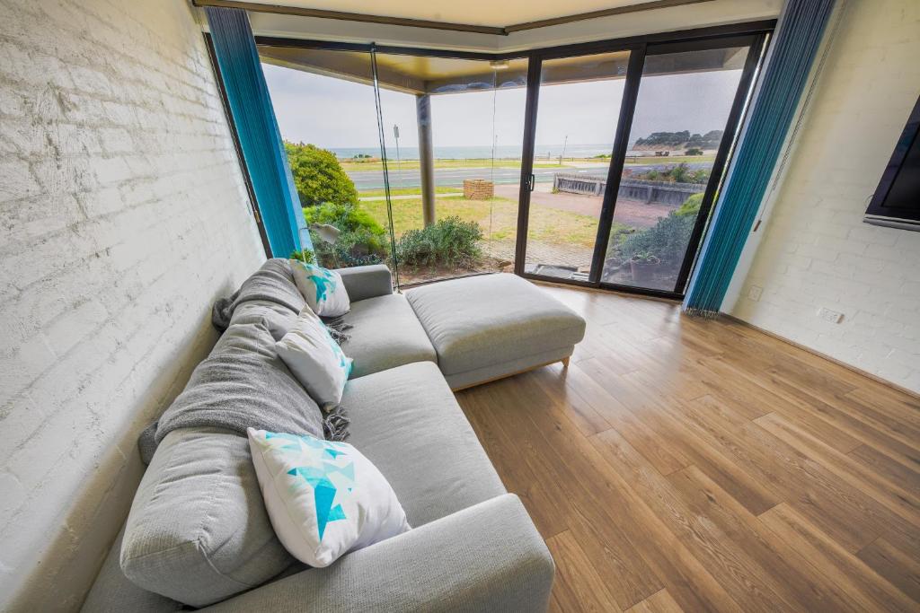 a living room with a couch and a large window at Max's Beachside Holiday Home in Torquay