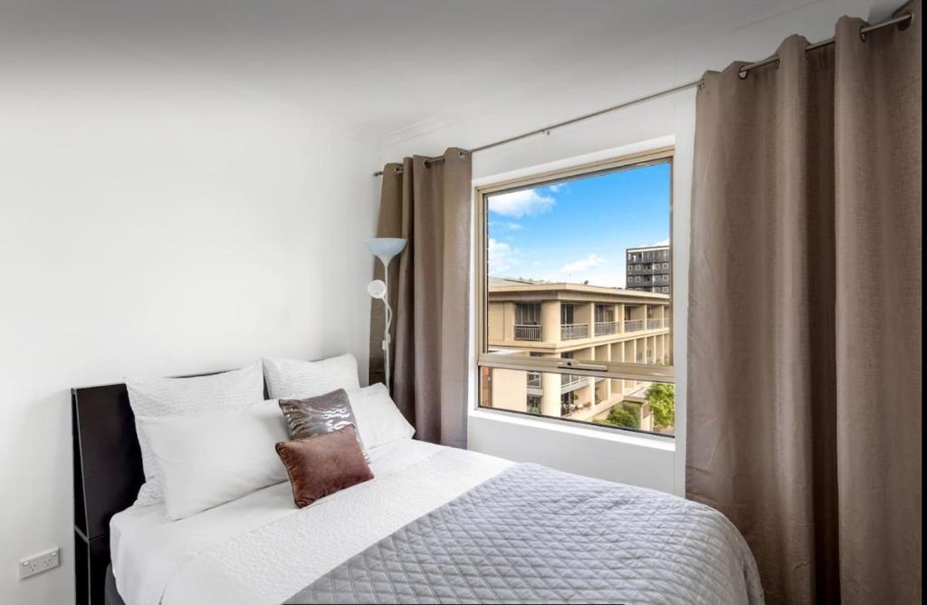 a bedroom with a bed and a large window at Forest of Dreams in Adelaide