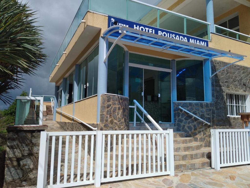 a building with a sign for the hotel download main at Hotel Pousada Miami in Itanhaém