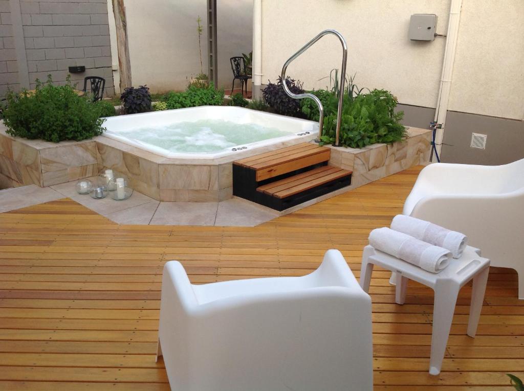 a jacuzzi tub in a room with two white chairs at 770 Apart in Villa Carlos Paz