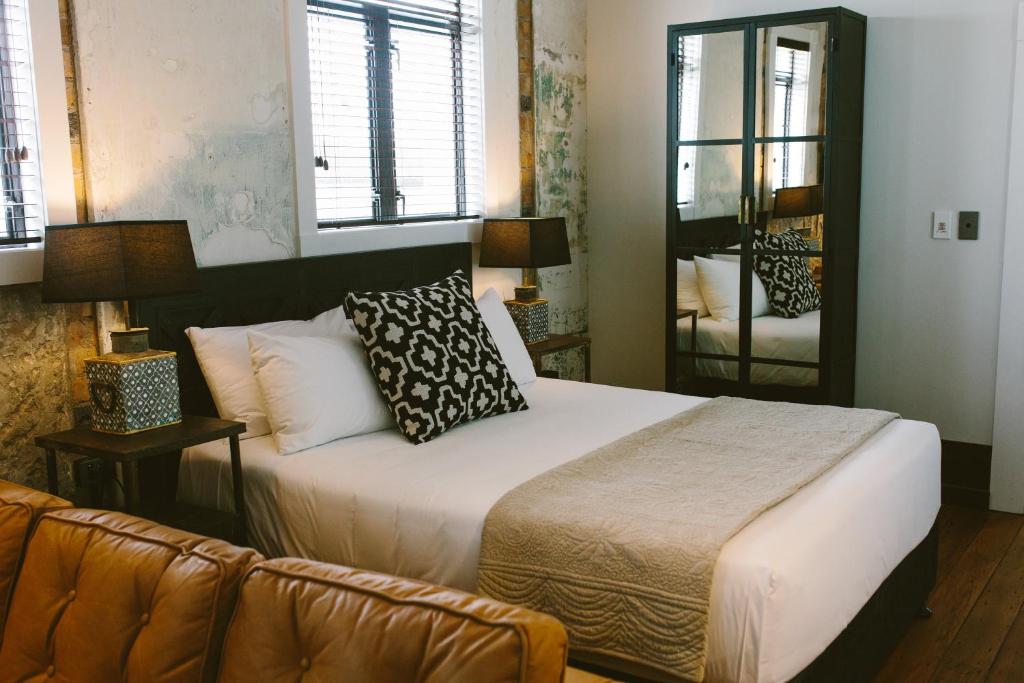 a bedroom with a bed and a couch at The Convent Hotel in Auckland