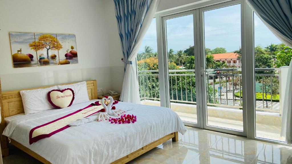 a bedroom with a bed and a large window at Sao Mai hotel in Con Dao