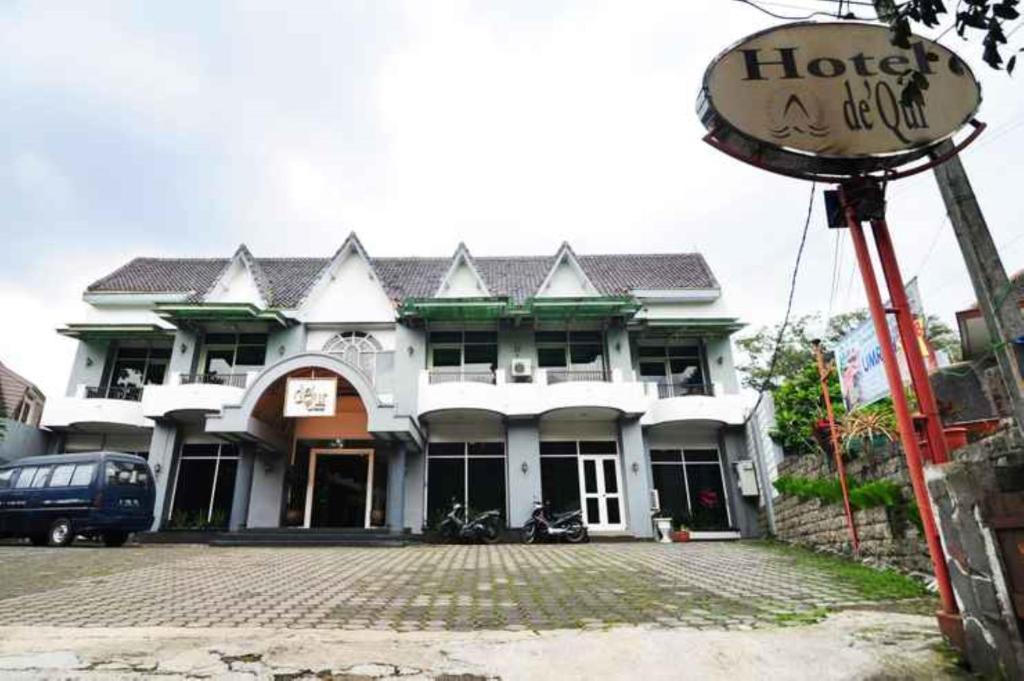 ein großes weißes Gebäude mit einem Schild davor in der Unterkunft De'Qur Hotel Bandung in Bandung