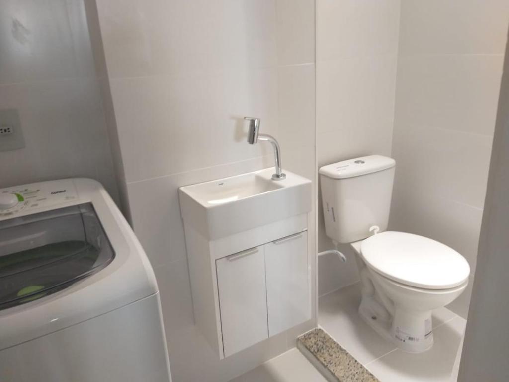 une salle de bain blanche avec toilettes et lavabo dans l'établissement ACONCHEGO A BEIRA MAR, à Rio de Janeiro