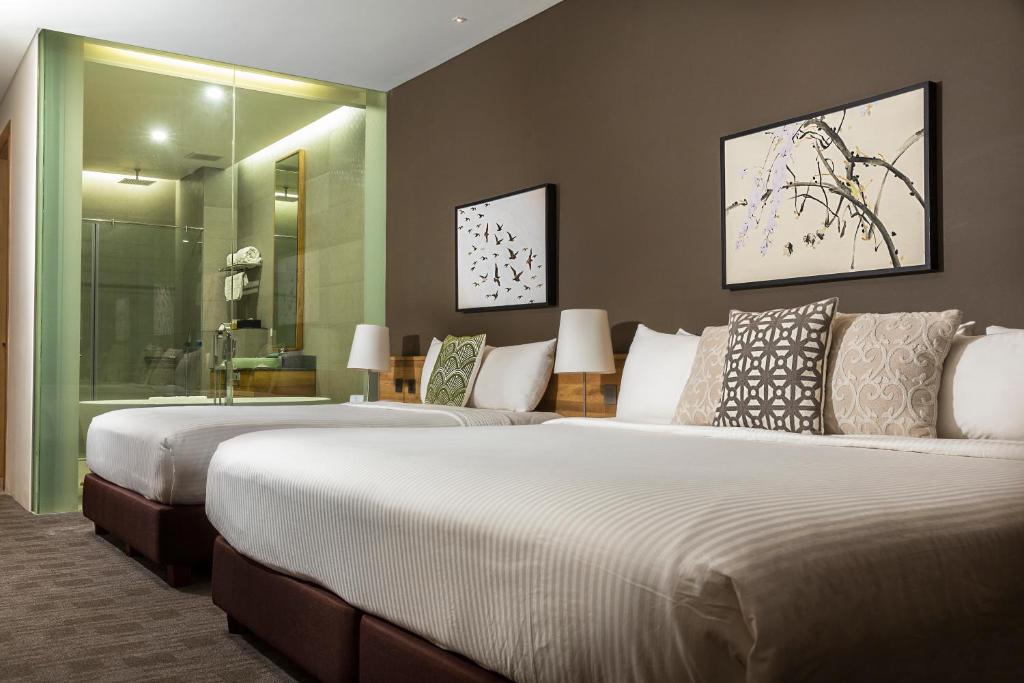 2 Betten in einem Hotelzimmer mit in der Unterkunft Escala Tagaytay in Tagaytay