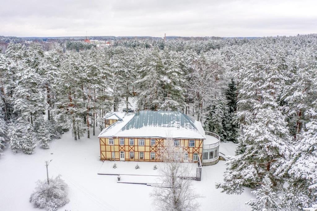 a house with a green roof in the snow at Verevi Motel in Elva