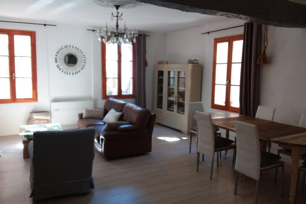 ein Wohnzimmer mit einem Sofa und einem Tisch in der Unterkunft L'Appart à Cotignac, tout compris, calme et confort in Cotignac
