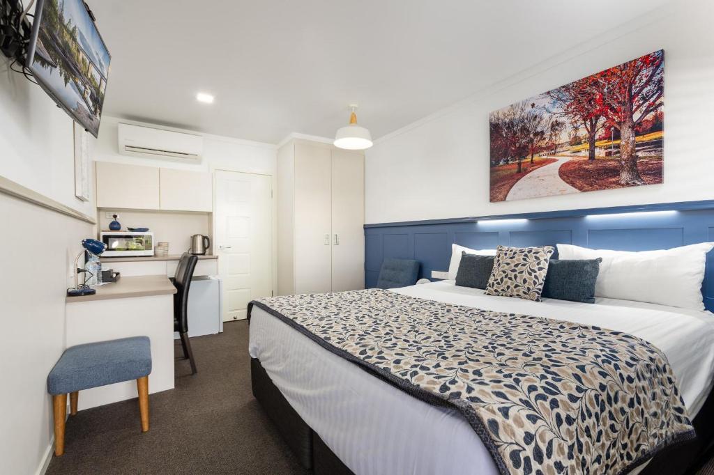a bedroom with a bed and a desk at Granite Belt Motel in Stanthorpe
