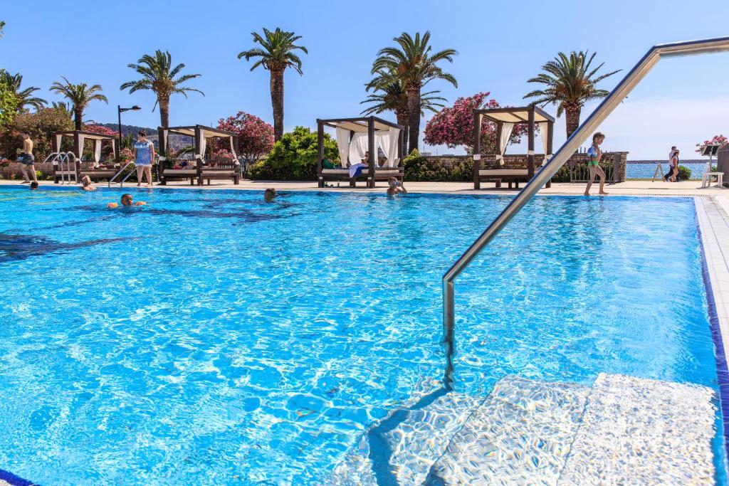 a swimming pool at a resort with palm trees at Hotel Princess in Bar