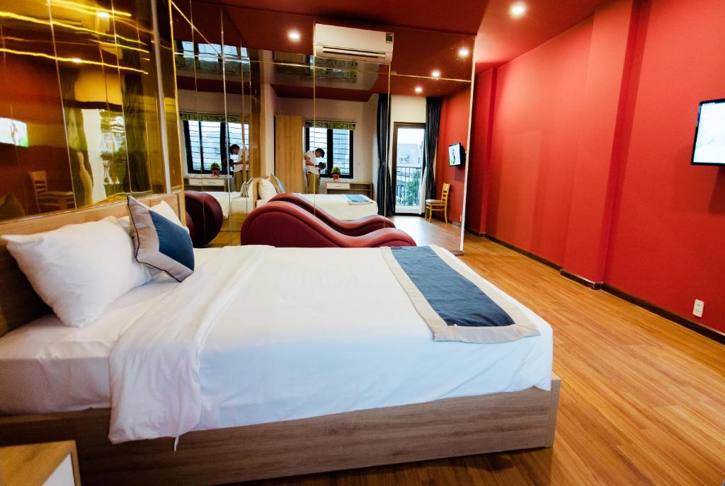een slaapkamer met een groot bed en een rode muur bij Mata Love Hotel in Da Nang