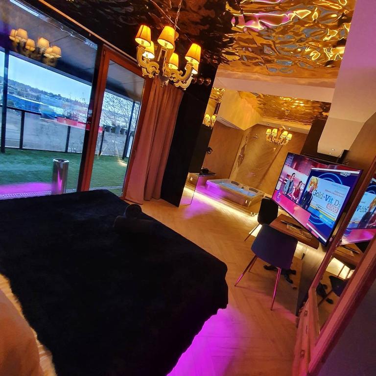 a bedroom with a bed and a tv and purple lights at Hotel Ramka & Restaurant & Wine Bar in Poznań
